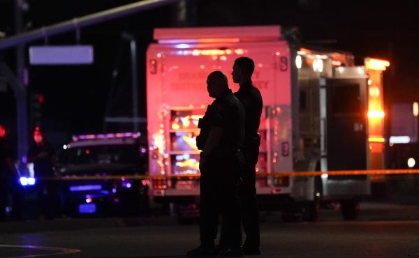 Two police officers stand outside an office building where a shooting occurred in Orange, Calif., Wednesday, March 31, 2021. The shooting killed several people, including a child, and injured another person before police shot the suspect, police said. Two police officers stand outside an office building where a shooting occurred in Orange, Calif., Wednesday, March 31, 2021. The shooting killed several people, including a child, and injured another person before police shot the suspect, police said.
