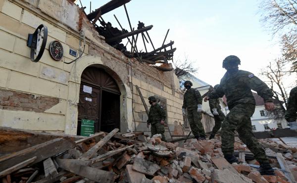 Croatian soldiers walk next to damaged buildings Tuesday in Petrinja, some 30 miles from the capital, Zagreb, after the town was hit by a 6.4 magnitude earthquake. Croatian soldiers walk next to damaged buildings Tuesday in Petrinja, some 30 miles from the capital, Zagreb, after the town was hit by a 6.4 magnitude earthquake.