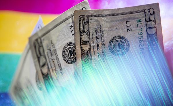 A photograph of three twenty dollar bills in front of bright, striped background. A prism warps the bottom of the money with glowing streaks in the bottom of the frame. A photograph of three twenty dollar bills in front of bright, striped background. A prism warps the bottom of the money with glowing streaks in the bottom of the frame.