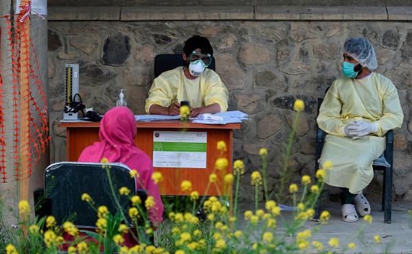 Medical staff wearing personal protective equipment register a suspected coronavirus patient in May at a Kabul hospital. Medical staff wearing personal protective equipment register a suspected coronavirus patient in May at a Kabul hospital.