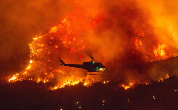 A helicopter prepares to drop water at a wildfire in Yucaipa, Calif., on Sept. 5. A firefighter was killed in the El Dorado blaze on Thursday. A helicopter prepares to drop water at a wildfire in Yucaipa, Calif., on Sept. 5. A firefighter was killed in the El Dorado blaze on Thursday.