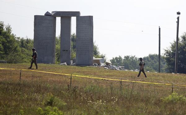 Law enforcement officials walk around the damaged Georgia Guidestones monument near Elberton, Ga., on Wednesday. Law enforcement officials walk around the damaged Georgia Guidestones monument near Elberton, Ga., on Wednesday.