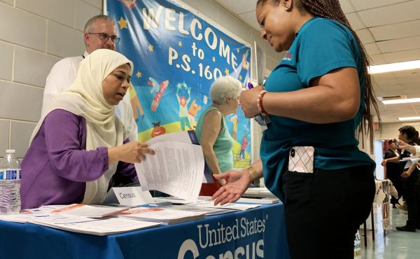 Census Bureau partnership specialist Zakera Ahmed (left) and Jeff Behler, a regional director with the bureau, share information about the 2020 census at an elementary school in Corona, N.Y., in July. Census Bureau partnership specialist Zakera Ahmed (left) and Jeff Behler, a regional director with the bureau, share information about the 2020 census at an elementary school in Corona, N.Y., in July.