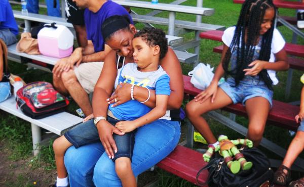 Five-year-old Kyle Romain sits on the lap of his grandmother, Barbara Romain, at a football game. Kyle lost his sight when he was hit by a stray bullet two months ago. Five-year-old Kyle Romain sits on the lap of his grandmother, Barbara Romain, at a football game. Kyle lost his sight when he was hit by a stray bullet two months ago.