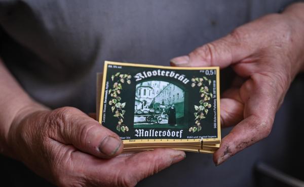 Sister Doris holds labels of the beer bottles with a painting of the former nun who was running the brewery. Sister Doris holds labels of the beer bottles with a painting of the former nun who was running the brewery.