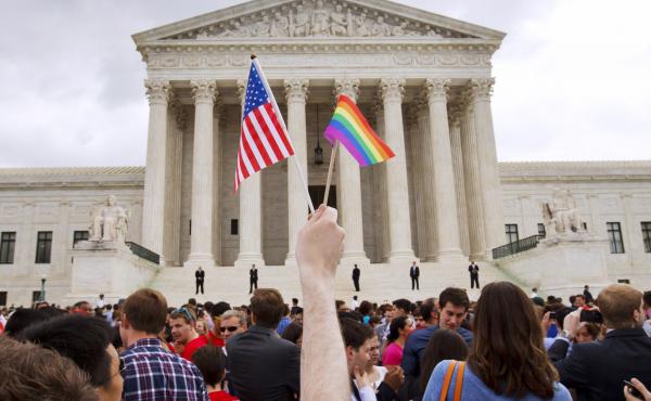A man holds a U.S. and a rainbow flag outside the Supreme Court in Washington, D.C., on June 26, 2015, after the court legalized gay marriage nationwide. A man holds a U.S. and a rainbow flag outside the Supreme Court in Washington, D.C., on June 26, 2015, after the court legalized gay marriage nationwide.