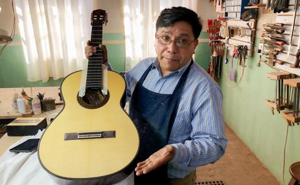 Master guitar maker Arnulfo Rubio Orozco holds up his latest project. It's taken him a month to craft this guitar with pearl accents and wood from southern Mexico. Master guitar maker Arnulfo Rubio Orozco holds up his latest project. It's taken him a month to craft this guitar with pearl accents and wood from southern Mexico.