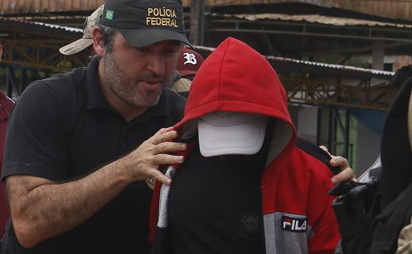 A police officer escorts a suspect in the area where Indigenous expert Bruno Pereira and freelance British journalist Dom Phillips disappeared, in Amazonas state, Brazil, June 15, 2022. A police officer escorts a suspect in the area where Indigenous expert Bruno Pereira and freelance British journalist Dom Phillips disappeared, in Amazonas state, Brazil, June 15, 2022.