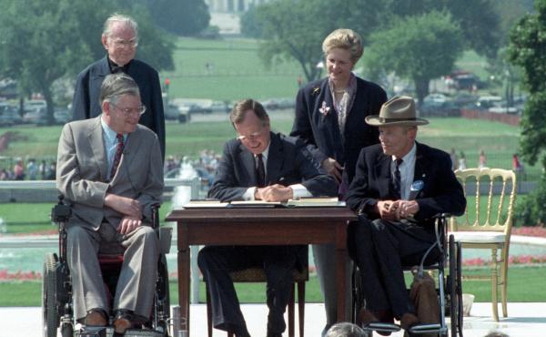 President George H. W. Bush signs the Americans with Disabilities Act on July 26, 1990. President George H. W. Bush signs the Americans with Disabilities Act on July 26, 1990.