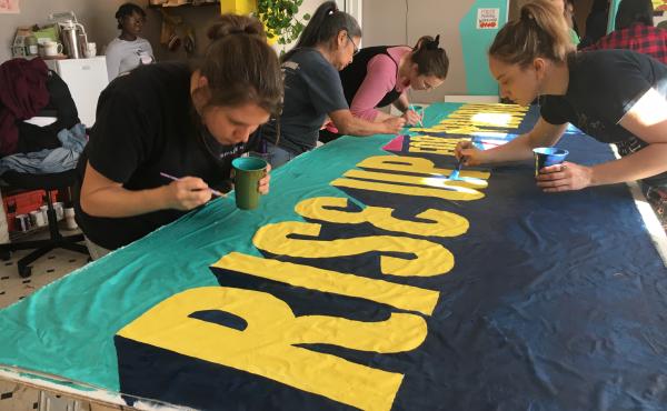 Volunteers paint a banner for the front of the demonstration. Organizers hosted the event to bring supporters together ahead of this year's Women's March, scheduled for Saturday. Volunteers paint a banner for the front of the demonstration. Organizers hosted the event to bring supporters together ahead of this year's Women's March, scheduled for Saturday.