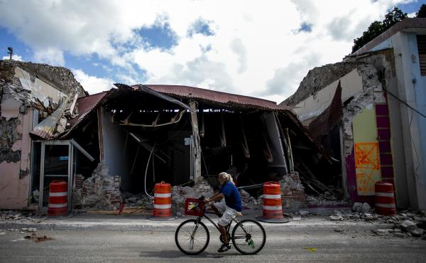 A cyclist rides past a destroyed building in Guanica, Puerto Rico. The island was hit by a series of earthquakes over the past couple of weeks, leading to a state of emergency, power outages and millions of dollars of damage. A cyclist rides past a destroyed building in Guanica, Puerto Rico. The island was hit by a series of earthquakes over the past couple of weeks, leading to a state of emergency, power outages and millions of dollars of damage.