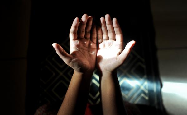 A Muslim woman prays in her home. A Muslim woman prays in her home.