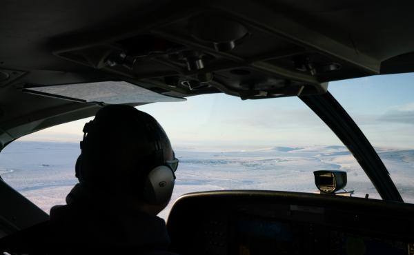 A RavnAir pilot guides a flight to Toksook Bay, Alaska, which can be seen out the window. A RavnAir pilot guides a flight to Toksook Bay, Alaska, which can be seen out the window.