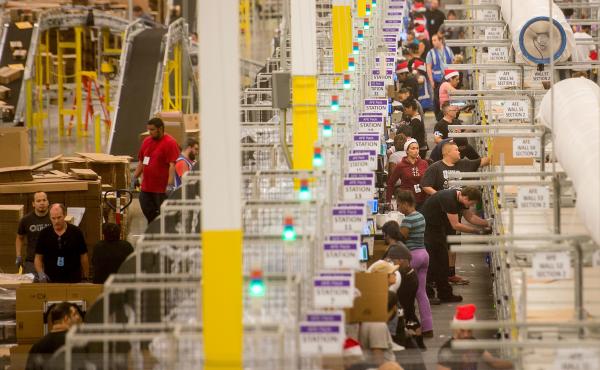 Amazon says it will pay all its U.S. workers at least $15 an hour. Here, workers prepare shipments at an Amazon Fulfillment Center in California during the early Christmas rush in 2014. Amazon says it will pay all its U.S. workers at least $15 an hour. Here, workers prepare shipments at an Amazon Fulfillment Center in California during the early Christmas rush in 2014.