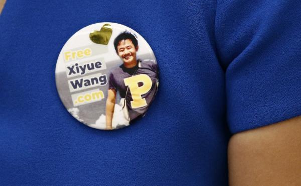 Hua Qu, the wife of Xiyue Wang, a Princeton University graduate student being held at an Iranian prison, wears a button bearing a picture of her husband as she speaks at a news conference to mark the third anniversary of his imprisonment, Aug. 8, 2019, in Hua Qu, the wife of Xiyue Wang, a Princeton University graduate student being held at an Iranian prison, wears a button bearing a picture of her husband as she speaks at a news conference to mark the third anniversary of his imprisonment, Aug. 8, 2019, in