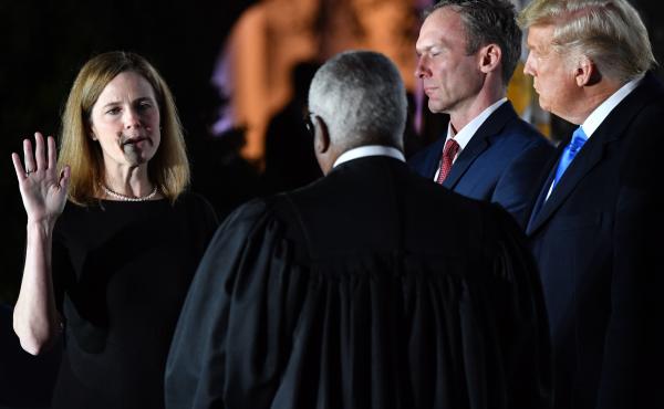 President Trump watches as Supreme Court Justice Clarence Thomas administers the constitutional oath to Amy Coney Barrett during a ceremony at the White House Monday evening. President Trump watches as Supreme Court Justice Clarence Thomas administers the constitutional oath to Amy Coney Barrett during a ceremony at the White House Monday evening.