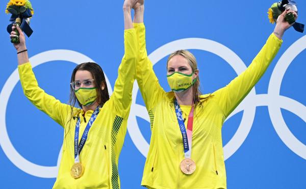 Australian gold medalist Kaylee McKeown (left) poses with bronze medalist and teammate Emily Seebohm, who she invited to the top podium after the women's 200-meter backstroke swimming final at the Tokyo Olympics on Saturday. Australian gold medalist Kaylee McKeown (left) poses with bronze medalist and teammate Emily Seebohm, who she invited to the top podium after the women's 200-meter backstroke swimming final at the Tokyo Olympics on Saturday.