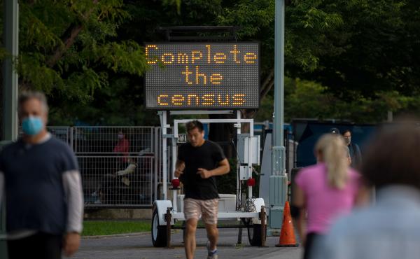 People pass by a "Complete the census" sign along New York City's Hudson River Greenway in September 2020. People pass by a "Complete the census" sign along New York City's Hudson River Greenway in September 2020.