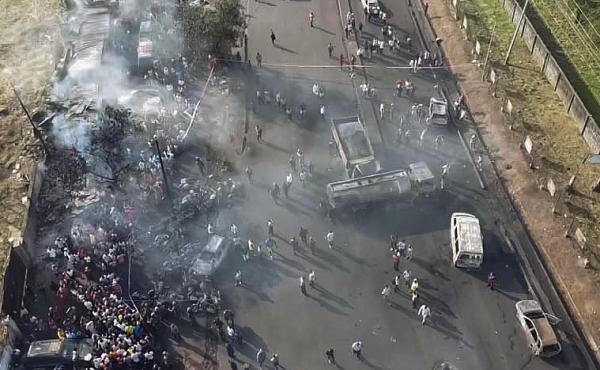 In this photograph issued Saturday by Sierra Leone's National Disaster Management Agency, people gather around the charred oil tanker that exploded after being struck by a truck in the Wellington suburb of Sierra Leone's capital Freetown on Saturday. In this photograph issued Saturday by Sierra Leone's National Disaster Management Agency, people gather around the charred oil tanker that exploded after being struck by a truck in the Wellington suburb of Sierra Leone's capital Freetown on Saturday.