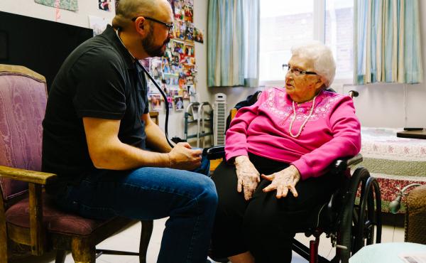 Glenn Hurst gives Jeannette Massen a checkup at the Northcrest Living Center in Council Bluffs, Iowa. As they prepare to caucus, voters weigh which candidate to support and what health care should look like in the future. Glenn Hurst gives Jeannette Massen a checkup at the Northcrest Living Center in Council Bluffs, Iowa. As they prepare to caucus, voters weigh which candidate to support and what health care should look like in the future.