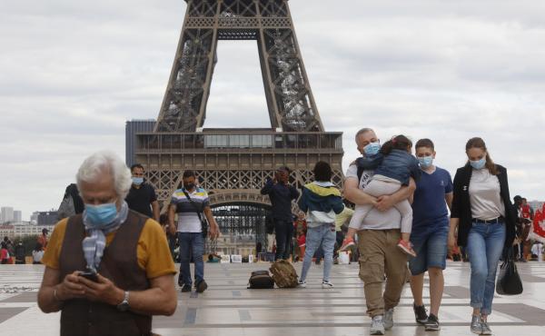 People wearing masks walk near the Eiffel Tower in Paris on Thursday, the same day that the government made masks mandatory in all the city's public outdoor spaces. People wearing masks walk near the Eiffel Tower in Paris on Thursday, the same day that the government made masks mandatory in all the city's public outdoor spaces.