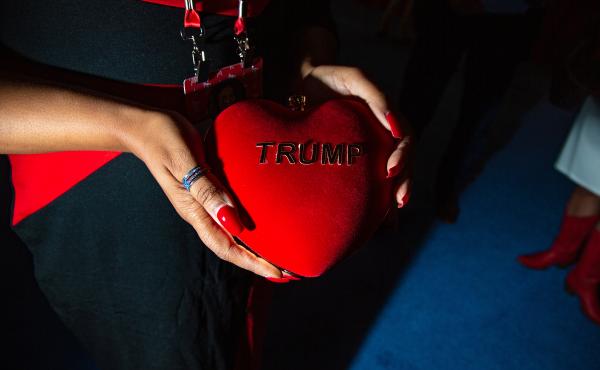 A CPAC attendee holds a heart shaped purse reading "Trump." A CPAC attendee holds a heart shaped purse reading "Trump."