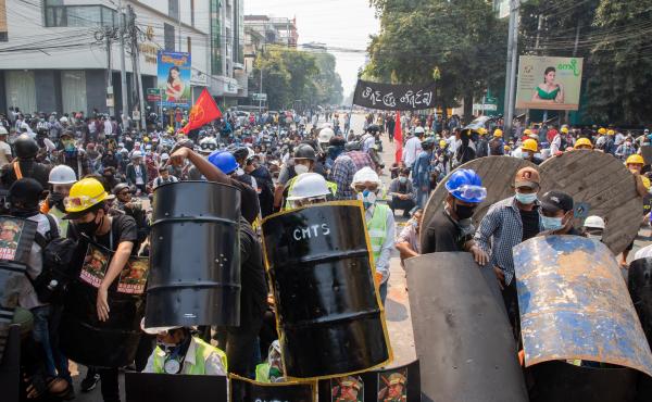 Demonstrators take shelter and block the road during a protest against the military coup in Mandalay, Myanmar on Wednesday. Demonstrators take shelter and block the road during a protest against the military coup in Mandalay, Myanmar on Wednesday.