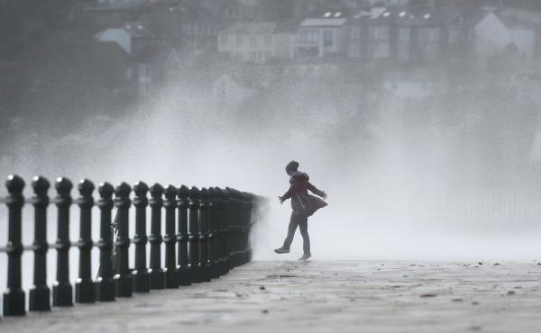 A woman stands as waves crash against the sea wall at Penzance, southwestern England, as the remnants of Ophelia begin to hit parts of the U.K. and Ireland. A woman stands as waves crash against the sea wall at Penzance, southwestern England, as the remnants of Ophelia begin to hit parts of the U.K. and Ireland.