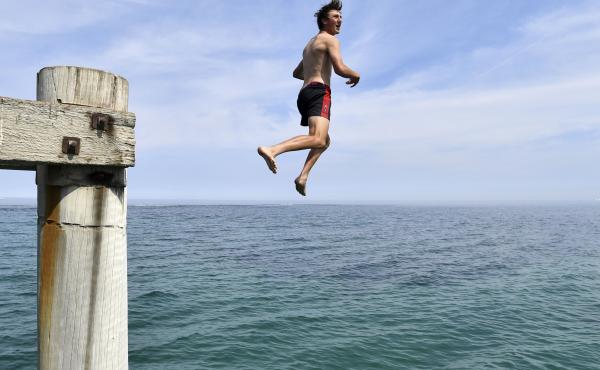 A swimmer jumps from a jetty in an effort to cool off in Adelaide, Australia, as the country experiences record temperatures. A swimmer jumps from a jetty in an effort to cool off in Adelaide, Australia, as the country experiences record temperatures.
