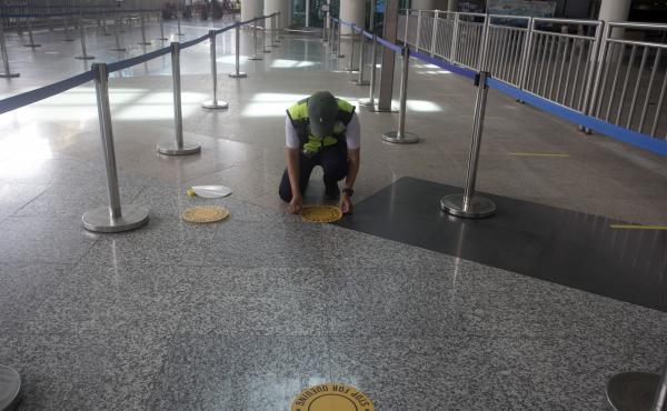 An airport worker marks queue line for the reopening of International Ngurah Rai Airport in Bali, Indonesia, Thursday. An airport worker marks queue line for the reopening of International Ngurah Rai Airport in Bali, Indonesia, Thursday.