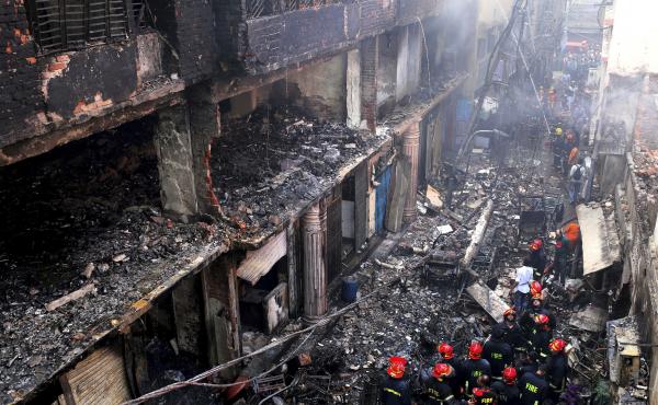 Locals and firefighters gather around buildings that caught fire late Wednesday in Dhaka, Bangladesh, on Thursday, killing dozens of people. Locals and firefighters gather around buildings that caught fire late Wednesday in Dhaka, Bangladesh, on Thursday, killing dozens of people.
