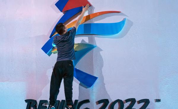 A crew member leaps to fix a logo for the 2022 Winter Olympics in Beijing earlier this month. The International Olympic Committee says it will allow fans from mainland China to attend the competition in person. A crew member leaps to fix a logo for the 2022 Winter Olympics in Beijing earlier this month. The International Olympic Committee says it will allow fans from mainland China to attend the competition in person.