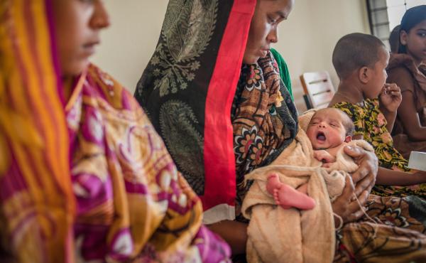 Rong Mala, 30, holds her 6-day-old child, Rakhal, as she waits to see the paramedic at a government clinic in Bangladesh. Rong Mala, 30, holds her 6-day-old child, Rakhal, as she waits to see the paramedic at a government clinic in Bangladesh.