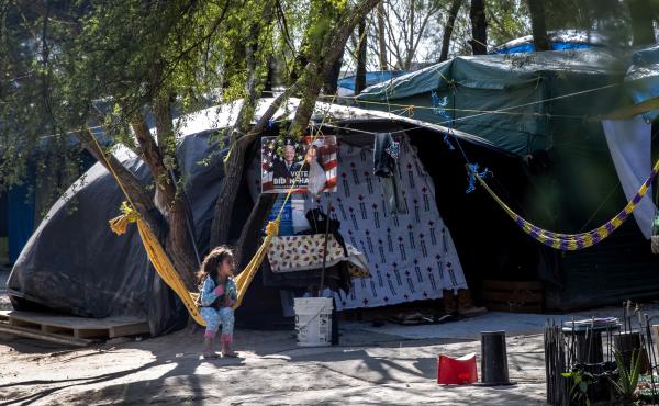 A Salvadoran girl sits inside a camp for asylum-seekers on Sunday in Matamoros, Mexico, where some 600 people who left Central America have been waiting for immigration court hearings. A Salvadoran girl sits inside a camp for asylum-seekers on Sunday in Matamoros, Mexico, where some 600 people who left Central America have been waiting for immigration court hearings.