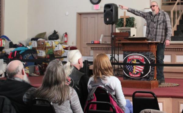 Pastor Tim Theriault preaches during a Sunday morning service at Biker Church USA, housed inside a large brick building in Bangor, Maine. The church purchased the building this year and has turned it into a warming shelter for homeless residents. Pastor Tim Theriault preaches during a Sunday morning service at Biker Church USA, housed inside a large brick building in Bangor, Maine. The church purchased the building this year and has turned it into a warming shelter for homeless residents.