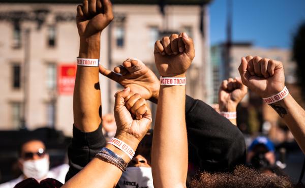 Black Lives Matter protesters display wristbands reading "I Voted" after leaving a polling place this month in Louisville, Ky. Activists warn Black and Latino voters are being flooded with disinformation intended to suppress turnout in the election's fina Black Lives Matter protesters display wristbands reading "I Voted" after leaving a polling place this month in Louisville, Ky. Activists warn Black and Latino voters are being flooded with disinformation intended to suppress turnout in the election's fina