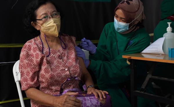A resident receives a dose of the Pfizer COVID-19 vaccine at a health center in Jakarta, Indonesia, on Jan. 13. This week, Indonesia started a program to give booster shots to the elderly and people at risk of severe disease. A resident receives a dose of the Pfizer COVID-19 vaccine at a health center in Jakarta, Indonesia, on Jan. 13. This week, Indonesia started a program to give booster shots to the elderly and people at risk of severe disease.