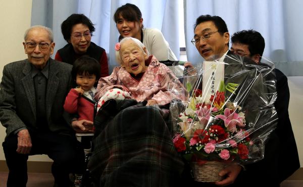 Misao Okawa, the world's oldest living person, poses for a photo with her son Hiroshi Okawa, 92, (left) and other family members and friends on her 117th birthday celebration at Kurenai Nursing Home in Osaka, Japan. Misao Okawa, the world's oldest living person, poses for a photo with her son Hiroshi Okawa, 92, (left) and other family members and friends on her 117th birthday celebration at Kurenai Nursing Home in Osaka, Japan.