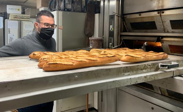Tony Doré wears a face mask as baguettes cool in his bakery in Paris' 15th arrondissement. Tony Doré wears a face mask as baguettes cool in his bakery in Paris' 15th arrondissement.