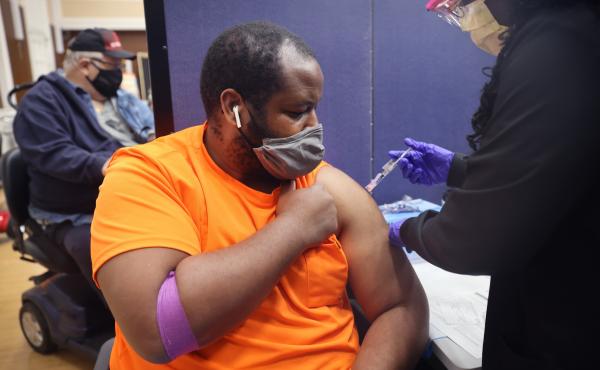 Gloria Clemons gives a COVID-19 vaccine to Navy veteran Perry Johnson at the Edward Hines, Jr. VA Hospital in Hines, Ill., in September. Gloria Clemons gives a COVID-19 vaccine to Navy veteran Perry Johnson at the Edward Hines, Jr. VA Hospital in Hines, Ill., in September.