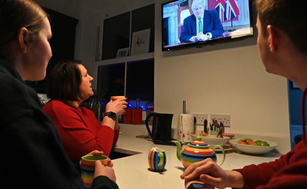 A family gathers around the television Monday in Liverpool, England, to watch Prime Minister Boris Johnson speak to the nation about the new lockdown. A family gathers around the television Monday in Liverpool, England, to watch Prime Minister Boris Johnson speak to the nation about the new lockdown.