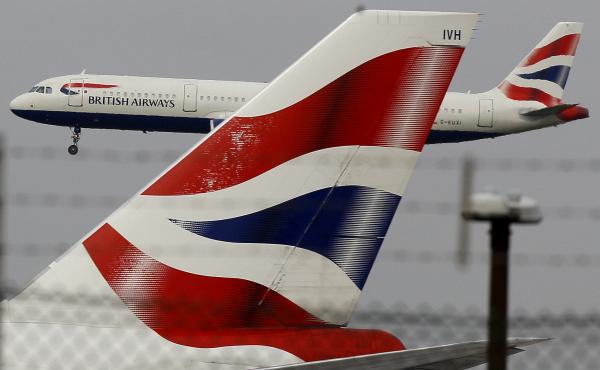 A British Airways plane comes in to land behind a tail fin at Heathrow Airport in London. On Friday, the head of the group that owns BA called for instituting an electronic health pass for passengers as the company announced steep losses due to COVID-19. A British Airways plane comes in to land behind a tail fin at Heathrow Airport in London. On Friday, the head of the group that owns BA called for instituting an electronic health pass for passengers as the company announced steep losses due to COVID-19.