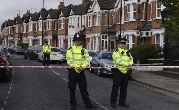 Police cordon off part of London's Harlesden Road on Friday, after counterterrorism police shot a woman and arrested several people in raids in London and southeastern England. Police cordon off part of London's Harlesden Road on Friday, after counterterrorism police shot a woman and arrested several people in raids in London and southeastern England.