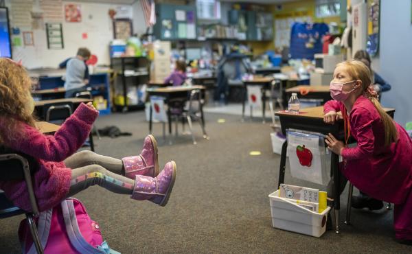 Two first grade students talk in the back of class at the Green Mountain School last month in Woodland, Wash. The CDC's current guidance for schools recommends seating or desks be "at least 6 feet apart when feasible." Two first grade students talk in the back of class at the Green Mountain School last month in Woodland, Wash. The CDC's current guidance for schools recommends seating or desks be "at least 6 feet apart when feasible."