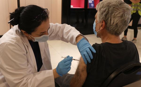 Safeway pharmacist Shahrzad Khoobyari administers a Pfizer-BioNTech COVID-19 booster shot into the arm of Norman Solomon in San Rafael, Calif., in October. Safeway pharmacist Shahrzad Khoobyari administers a Pfizer-BioNTech COVID-19 booster shot into the arm of Norman Solomon in San Rafael, Calif., in October.