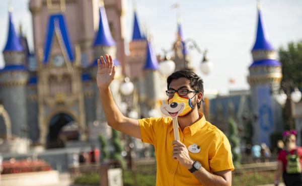 A Disney employee welcomes guests to Walt Disney World Resort on July 11, 2020 in Lake Buena Vista, Fla. Disney has paused its COVID-19 vaccine mandate to comply with a new Florida law. A Disney employee welcomes guests to Walt Disney World Resort on July 11, 2020 in Lake Buena Vista, Fla. Disney has paused its COVID-19 vaccine mandate to comply with a new Florida law.
