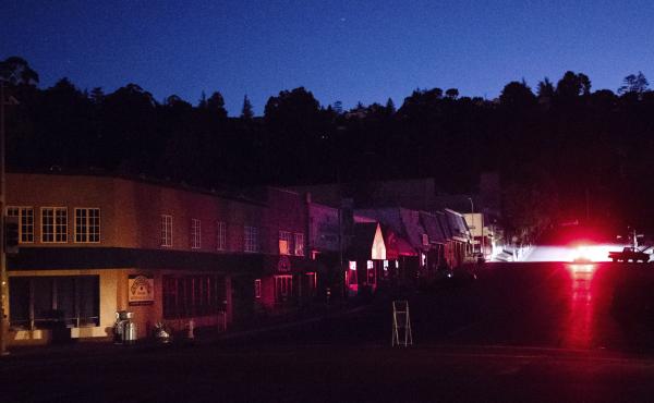 A car drives through a darkened Montclair Village in Oakland, Calif., after Pacific Gas & Electric shutdown power last week to prevent wildfires. A car drives through a darkened Montclair Village in Oakland, Calif., after Pacific Gas & Electric shutdown power last week to prevent wildfires.