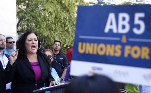 Democratic Assemblywoman Lorena Gonzalez speaks at a July rally for independent contractors in Sacramento, Calif. The measure that passed Tuesday in the state Senate requires companies such as Lyft and Uber to turn many contract workers into employees. Democratic Assemblywoman Lorena Gonzalez speaks at a July rally for independent contractors in Sacramento, Calif. The measure that passed Tuesday in the state Senate requires companies such as Lyft and Uber to turn many contract workers into employees.