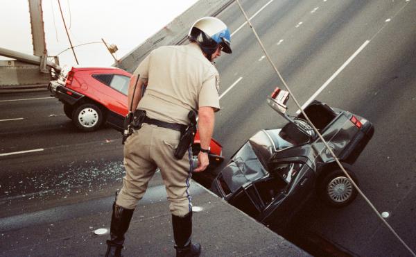 A California Highway Patrol officer checks cars that fell when the upper deck of the San Francisco Bay Bridge collapsed onto the lower deck after the 1989 Loma Prieta earthquake. A California Highway Patrol officer checks cars that fell when the upper deck of the San Francisco Bay Bridge collapsed onto the lower deck after the 1989 Loma Prieta earthquake.