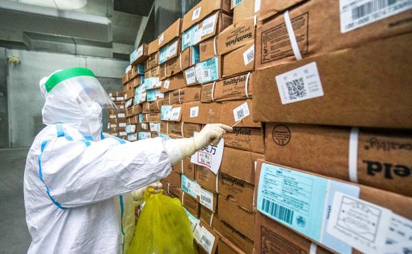 A health officer in a protective suit collects a sample from a package of imported frozen food for coronavirus rapid test at a wholesale market in China. A health officer in a protective suit collects a sample from a package of imported frozen food for coronavirus rapid test at a wholesale market in China.